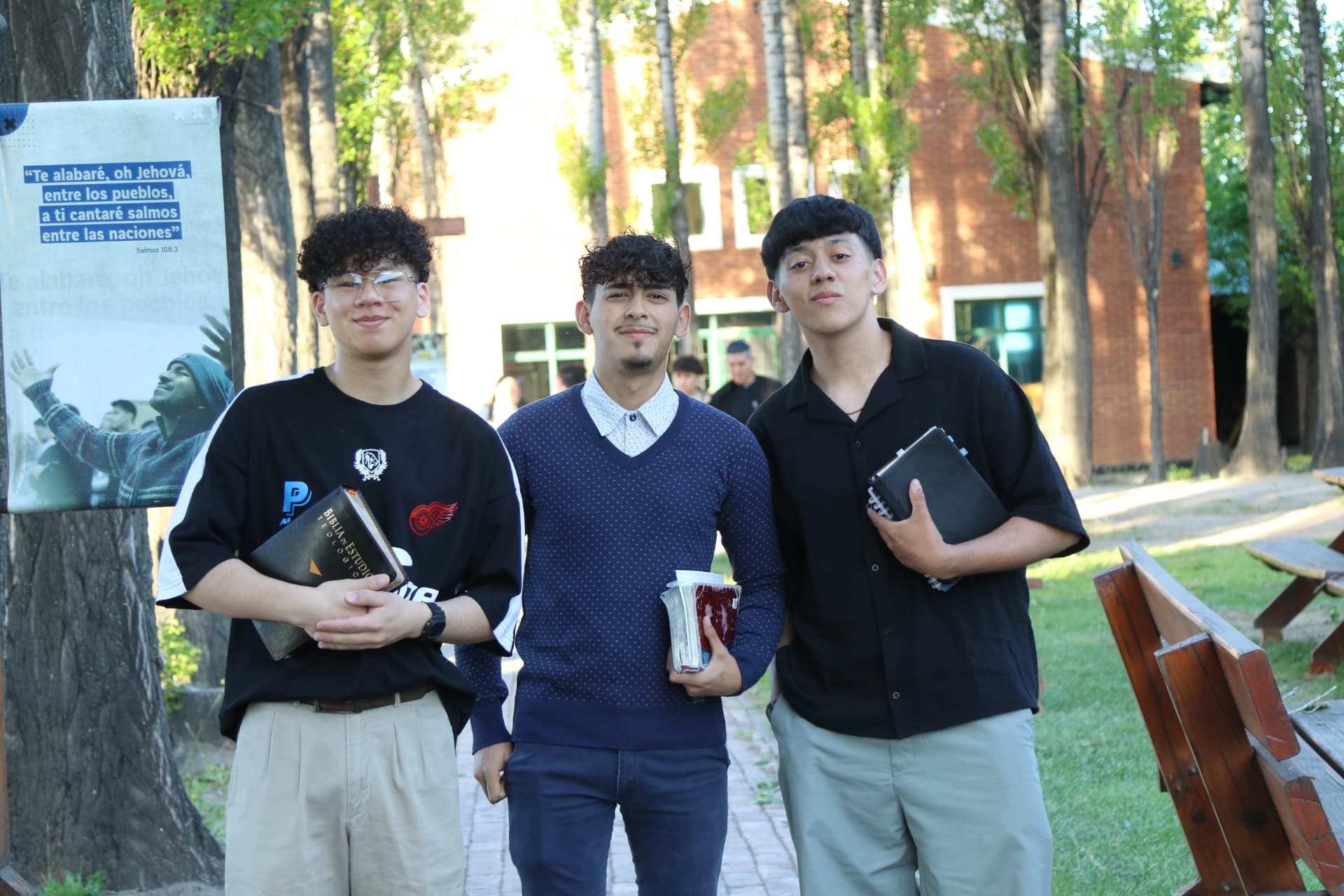 Estudiantes varones con sus Biblias caminando por el parque